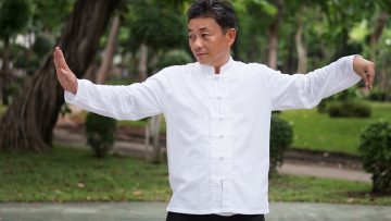 old man practicing kungfu or tai chi in the park, healthy lifestyle meditation exercise concept